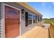 Inviting porch with a colorful front door, and black shutters at 130 Ruby Trl, Roxboro, NC 27574