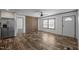 A living room features woodgrain flooring, a ceiling fan, a pair of windows, and a white front door at 130 Ruby Trl, Roxboro, NC 27574