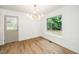 Dining room boasting modern light fixture, hardwood floors, a bright window, and a side door to the exterior at 1308 Broken Branch Ct, Raleigh, NC 27610