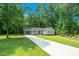 Charming single-story home with an attached carport, well-manicured lawn, and a long driveway leading up to the entrance at 1308 Broken Branch Ct, Raleigh, NC 27610