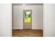 Hallway view features wood-look floors, white walls, and a view of the front yard from the front door window at 1308 Broken Branch Ct, Raleigh, NC 27610