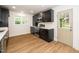 Well-lit kitchen with modern appliances, white countertops, black cabinets and wood-look flooring at 1308 Broken Branch Ct, Raleigh, NC 27610