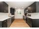 Bright kitchen showcasing stainless steel appliances, white countertops, sleek black cabinets, and wood-look flooring at 1308 Broken Branch Ct, Raleigh, NC 27610