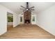 Bright living room showcasing hardwood floors, a brick fireplace, windows, and vaulted ceilings at 1308 Broken Branch Ct, Raleigh, NC 27610