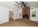 Bright living room with hardwood floors, brick fireplace, statement ceiling fan, and access to a dining room at 1308 Broken Branch Ct, Raleigh, NC 27610