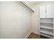 Walk-in closet with white shelving, cabinet, wood-look floors, and ample storage space for clothing and accessories at 1308 Broken Branch Ct, Raleigh, NC 27610