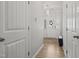 Bright hallway with wood floors, white doors, and a stylish light fixture at 136 Thornhill Dr, Burlington, NC 27215