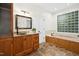Charming bathroom with stone countertops and a unique bathtub with glass block window at 139 Trillium Pl, Chapel Hill, NC 27517