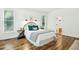 Cozy bedroom features a decorative headboard, wood floors, and natural light from two windows at 139 Trillium Pl, Chapel Hill, NC 27517