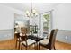Bright dining room features stylish lighting, chair rail, and glass table top at 139 Trillium Pl, Chapel Hill, NC 27517