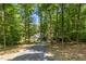 A long driveway leads to a charming residence nestled in a lush, green forest at 139 Trillium Pl, Chapel Hill, NC 27517