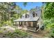 Exterior view of a charming home with a inviting covered front porch nestled in a serene wooded landscape at 139 Trillium Pl, Chapel Hill, NC 27517