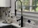 Modern kitchen faucet detail with stylish tile backsplash and sink at 139 Trillium Pl, Chapel Hill, NC 27517