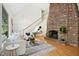 Bright living room featuring a brick fireplace, hardwood floors, and a staircase leading to the second floor at 139 Trillium Pl, Chapel Hill, NC 27517