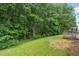 View of a lush green backyard with mature trees and a wooden deck, offering privacy at 1406 Pebble Creek Xing, Durham, NC 27713