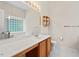 Well-lit bathroom featuring a vanity, a decorative shelf and a bathtub with a glass block window at 1406 Pebble Creek Xing, Durham, NC 27713