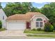 Charming one-story home with a two-car garage, red door, and inviting curb appeal at 1406 Pebble Creek Xing, Durham, NC 27713