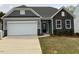 Charming home with a well-maintained lawn, an attached garage, and stylish stone accents at 146 Verona Villa Dr, Burlington, NC 27215
