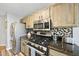 Modern kitchen featuring stainless steel appliances, granite countertops, and wooden cabinets at 1634 Claiborne Ct, Raleigh, NC 27606