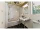 White bathroom features white tile, black tile floor, and a sink and tub/shower combination at 1846 Hammond St, Rocky Mount, NC 27803