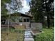 Landscaped front yard with stone steps leading to a stone home surrounded by mature trees at 1846 Hammond St, Rocky Mount, NC 27803