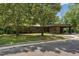 Modern stone home with a porte-cochere and mature trees providing shade at 1846 Hammond St, Rocky Mount, NC 27803