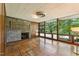 Cozy living room featuring a stone fireplace, tile flooring, wood paneled walls, and large windows with green views at 1846 Hammond St, Rocky Mount, NC 27803