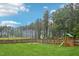The backyard features an expansive lawn, wooden fence, and a playset, perfect for Gathering fun at 195 Solomon Dr, Cameron, NC 28326