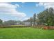 Sprawling backyard with lush green grass, wood fence, and playset for children to enjoy outdoor activities at 195 Solomon Dr, Cameron, NC 28326
