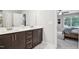 Bathroom featuring double sinks, dark wood cabinets, large mirrors and a view into an adjacent bedroom at 195 Solomon Dr, Cameron, NC 28326