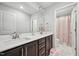 Bathroom featuring double sinks, dark wood cabinets, large mirrors and a view into an adjacent shower at 195 Solomon Dr, Cameron, NC 28326