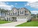 Spacious two-story home with a large yard, featuring a two-car garage and a welcoming front porch with rocking chairs at 195 Solomon Dr, Cameron, NC 28326