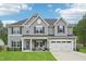 Charming two-story home featuring a well-manicured lawn, two-car garage, and inviting front porch with rocking chairs at 195 Solomon Dr, Cameron, NC 28326
