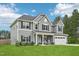 Attractive two-story home with a well-kept lawn, a convenient two-car garage, and a cozy front porch with seating at 195 Solomon Dr, Cameron, NC 28326