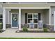 Inviting front porch with rocking chairs and a stylish front door adorned with a wreath, enhancing curb appeal at 195 Solomon Dr, Cameron, NC 28326