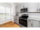Well-lit kitchen boasting stainless steel appliances, granite countertops, and hardwood flooring at 2001 Turtle Point Dr, Raleigh, NC 27604