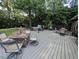 Back deck featuring a fire pit, hot tub, seating, and lush greenery, perfect for outdoor entertaining at 202 Howland Ave, Cary, NC 27513