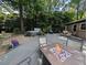 Back deck featuring a fire pit, hot tub, seating, and lush greenery, perfect for outdoor entertaining at 202 Howland Ave, Cary, NC 27513