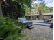Backyard with hot tub and patio area and brick house in the background. Beautiful landscaping at 202 Howland Ave, Cary, NC 27513