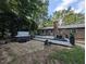 Backyard with hot tub, brick house, patio and nice landscaping on a sunny day at 202 Howland Ave, Cary, NC 27513