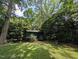 View of backyard shed on property with mature trees and lush, green landscaping at 202 Howland Ave, Cary, NC 27513
