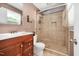 Bathroom featuring a wood vanity with sink, a toilet, and a glass-door shower at 202 Howland Ave, Cary, NC 27513