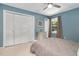 Comfortable bedroom featuring carpeted floors, neutral blue walls, a window, a ceiling fan, and a closet at 202 Howland Ave, Cary, NC 27513