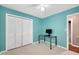 Bedroom featuring carpeted floors, blue walls, a window, a ceiling fan, a desk, and a closet at 202 Howland Ave, Cary, NC 27513