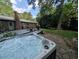 Relaxing hot tub with stone patio and a brick house, creating a backyard oasis for unwinding at 202 Howland Ave, Cary, NC 27513