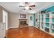 Living room featuring hardwood floors, a brick fireplace, a blue accent wall with built-in shelves, and a back door at 202 Howland Ave, Cary, NC 27513