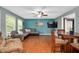 Open-concept living area with hardwood floors, a sectional sofa, and a mounted TV at 202 Howland Ave, Cary, NC 27513