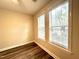 Bright empty bedroom with two windows offers a clean, neutral space with laminate flooring at 211 Providence Glen, Chapel Hill, NC 27514
