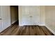 Bedroom with wood-look floors and white closet doors, offering ample storage at 211 Providence Glen, Chapel Hill, NC 27514