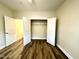 Cozy bedroom showcasing wood-look flooring and a closet with wide double doors at 211 Providence Glen, Chapel Hill, NC 27514